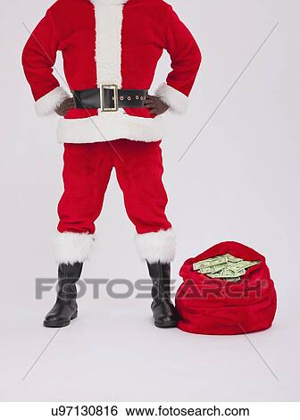 Stock Photograph - USA, Illinois, Metamora, low section of Santa Claus with sack of banknotes. Fotosearch