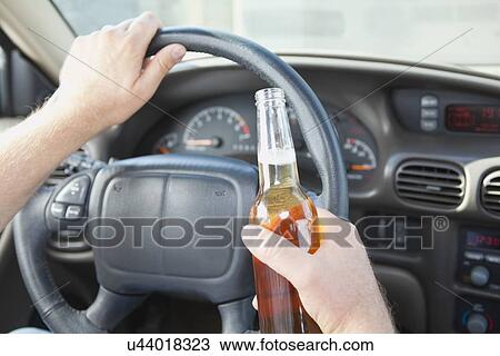 USA, Illinois, Metamora, Man driving with open bottle of beer View Large Photo Image Stock Image - USA, Illinois, Metamora, Man driving with open bottle of beer. Fotosearch