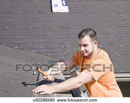 USA, Illinois, Metamora, Man hammering shingles onto roof View Large Photo Image Stock Image - USA, Illinois, Metamora, Man hammering shingles onto roof. Fotosearch