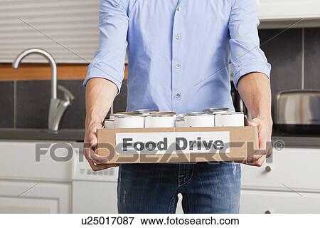USA, Illinois, Metamora, Man holding cardboard box with canned food in kitchen View Large Photo Image Stock Photo - USA, Illinois, Metamora, Man holding cardboard box with canned food in kitchen. Fotosearch