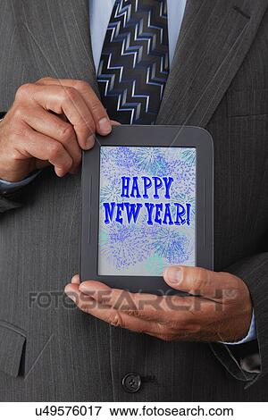 USA, Illinois, Metamora, Man holding tablet with 'Happy New Year' text on it View Large Photo Image Stock Photo - USA, Illinois, Metamora, Man holding tablet with 'Happy New Year' text on it. Fotosearch