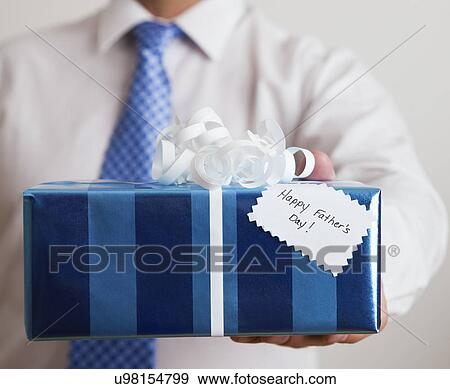 Stock Photo - USA, Illinois, Metamora, Man holding Father's day gift, close-up. Fotosearch