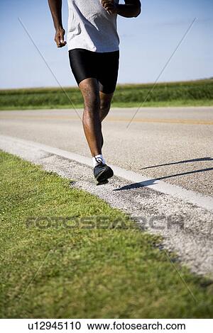 USA, Illinois, Metamora, man jogging down country road View Large Photo Image Stock Image - USA, Illinois, Metamora, man jogging down country road. Fotosearch