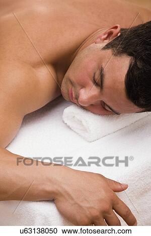 Stock Image - USA, Illinois, Metamora, Man lying on massage table. Fotosearch