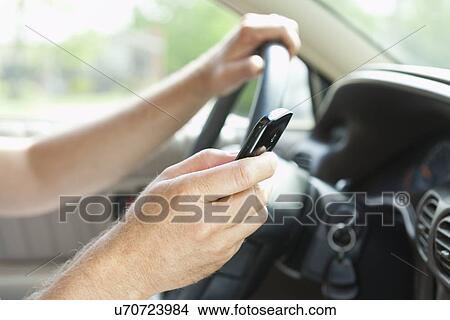 USA, Illinois, Metamora, Man texting on his mobile in car View Large Photo Image Picture - USA, Illinois, Metamora, Man texting on his mobile in car. Fotosearch