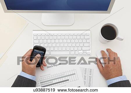 Stock Photo - USA, Illinois, Metamora, Man texting on his mobile in office. Fotosearch
