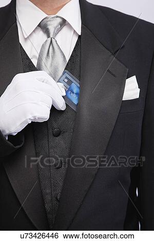 USA, Illinois, Metamora, Man wearing tuxedo holding card, mid section View Large Photo Image Stock Photograph - USA, Illinois, Metamora, Man wearing tuxedo holding card, mid section. Fotosearch