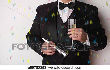 USA, Illinois, Metamora, Man with tuxedo holding champagne at party View Large Photo Image Stock Image - USA, Illinois, Metamora, Man with tuxedo holding champagne at party. Fotosearch