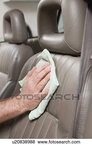 Stock Photo - USA, Illinois, Metamora, Man's hand cleaning leather car's seat. Fotosearch