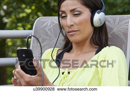 Stock Photo - USA, Illinois, Metamora, mature woman listening music from smart phone. Fotosearch