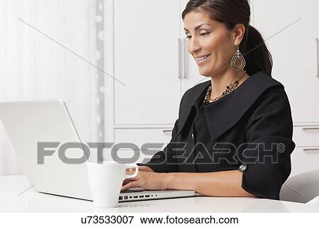 Stock Photo - USA, Illinois, Metamora, mature woman working on laptop. Fotosearch