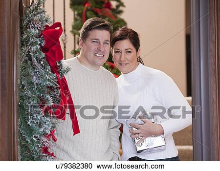USA, Illinois, Metamora, mid adult couple standing at door of house decorated for Christmas View Large Photo Image Stock Image - USA, Illinois, Metamora, mid adult couple standing at door of house decorated for Christmas. Fotosearch