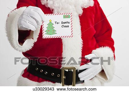 Stock Image - USA, Illinois, Metamora, Midsection of Santa Claus holding letter. Fotosearch
