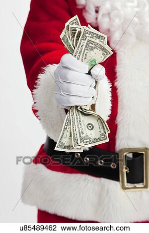 Stock Image - USA, Illinois, Metamora, Midsection of Santa Claus holding cash. Fotosearch