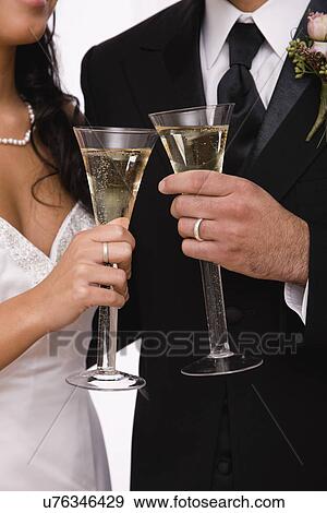 USA, Illinois, Metamora, Midsection of bride and groom toasting with champagne View Large Photo Image Stock Photo - USA, Illinois, Metamora, Midsection of bride and groom toasting with champagne. Fotosearch
