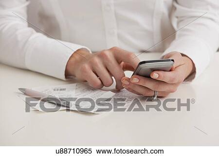 Stock Photography - USA, Illinois, Metamora, Midsection of woman using cell phone. Fotosearch