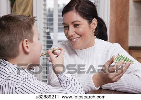 USA, Illinois, Metamora, mother and son (8-9) eating Christmas cookies View Large Photo Image Stock Image - USA, Illinois, Metamora, mother and son (8-9) eating Christmas cookies. Fotosearch