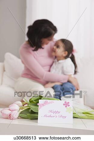 Stock Image - USA, Illinois, Metamora, mother and daughter (4-5) embracing on sofa. Fotosearch