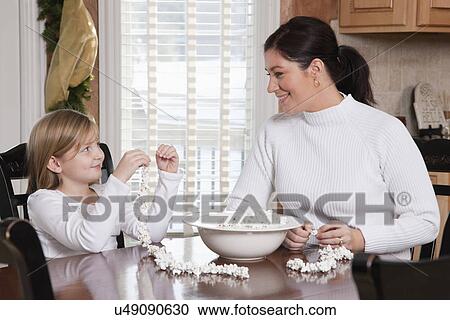 USA, Illinois, Metamora, mother and daughter (6-7) making popcorn Christmas ornament View Large Photo Image Stock Image - USA, Illinois, Metamora, mother and daughter (6-7) making popcorn Christmas ornament. Fotosearch