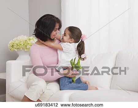 USA, Illinois, Metamora, mother and daughter (4-5) embracing on sofa View Large Photo Image Stock Image - USA, Illinois, Metamora, mother and daughter (4-5) embracing on sofa. Fotosearch