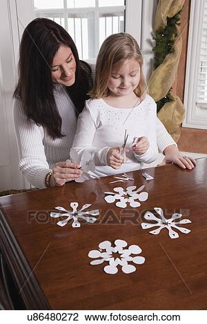 Stock Image - USA, Illinois, Metamora, mother and daughter making Christmas decoration. Fotosearch