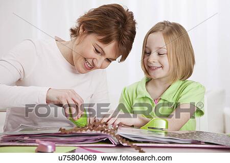 USA, Illinois, Metamora, Mother and daughter (8-9) making arts and crafts at table View Large Photo Image Stock Photo - USA, Illinois, Metamora, Mother and daughter (8-9) making arts and crafts at table. Fotosearch
