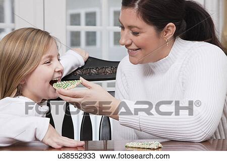 USA, Illinois, Metamora, mother feeding daughter (6-7) with Christmas cake View Large Photo Image Stock Image - USA, Illinois, Metamora, mother feeding daughter (6-7) with Christmas cake. Fotosearch