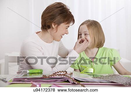 USA, Illinois, Metamora, Mother playing with daughter (8-9), papers on table in foreground View Large Photo Image Stock Photo - USA, Illinois, Metamora, Mother playing with daughter (8-9), papers on table in foreground. Fotosearch