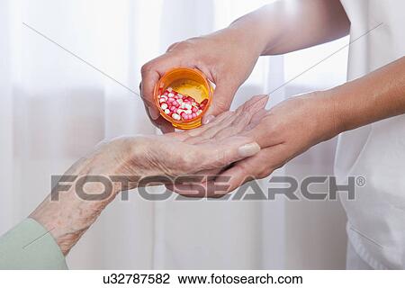 USA, Illinois, Metamora, Nurse giving pills to senior woman, close-up of hands View Large Photo Image Stock Image - USA, Illinois, Metamora, Nurse giving pills to senior woman, close-up of hands. Fotosearch