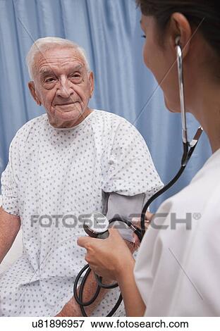 Stock Photo - USA, Illinois, Metamora, Nurse taking senior man's blood pressure. Fotosearch