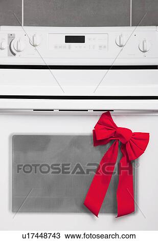 Stock Image - USA, Illinois, Metamora, Oven Christmas gift with bow. Fotosearch