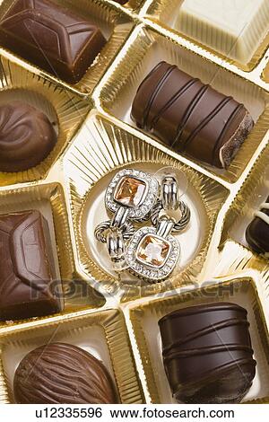 Stock Photograph - USA, Illinois, Metamora, Pair of earrings in box of chocolates. Fotosearch