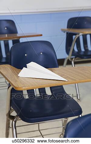 Stock Image - USA, Illinois, Metamora, Paper plane on desk in classroom. Fotosearch