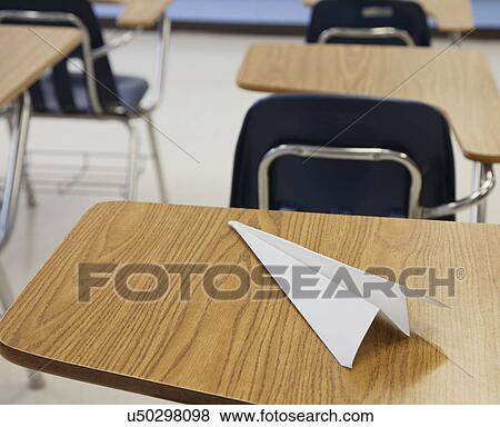 Stock Photo - USA, Illinois, Metamora, Paper plane on desk in classroom. Fotosearch