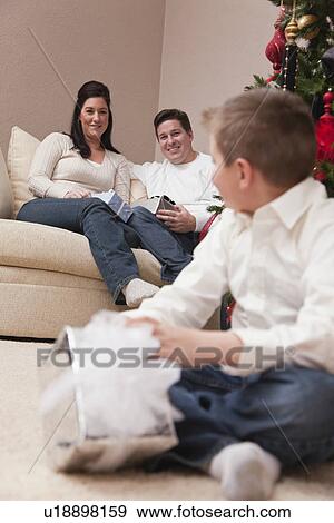 USA, Illinois, Metamora, parents and son sitting in living room and celebrating Christmas View Large Photo Image Stock Photo - USA, Illinois, Metamora, parents and son sitting in living room and celebrating Christmas. Fotosearch