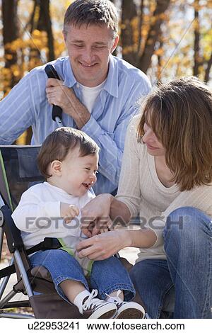 Stock Image - USA, Illinois, Metamora, parents with baby boy (12-17 months) in stroller. Fotosearch
