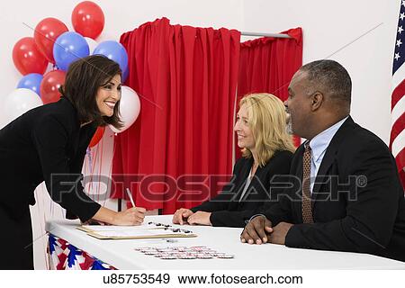 USA, Illinois, Metamora, People at polling place table, US flag, balloons and voting booth in background View Large Photo Image Stock Photo - USA, Illinois, Metamora, People at polling place table, US flag, balloons and voting booth in background. Fotosearch