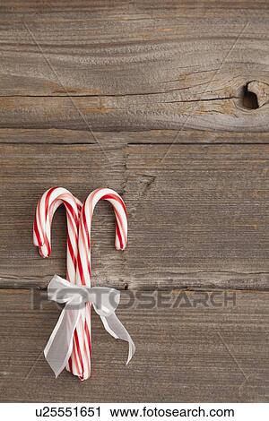 USA, Illinois, Metamora, Peppermint candy canes tied with white ribbon on wooden background View Large Photo Image Stock Image - USA, Illinois, Metamora, Peppermint candy canes tied with white ribbon on wooden background. Fotosearch