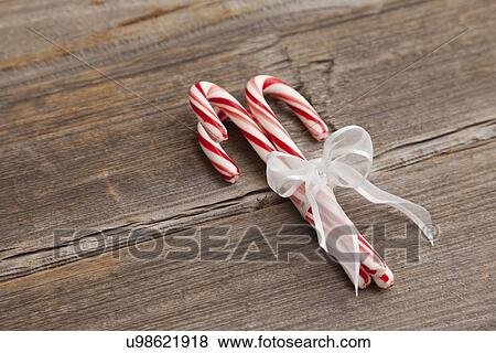 USA, Illinois, Metamora, Peppermint candy canes tied with white ribbon on wooden background View Large Photo Image Stock Photo - USA, Illinois, Metamora, Peppermint candy canes tied with white ribbon on wooden background. Fotosearch