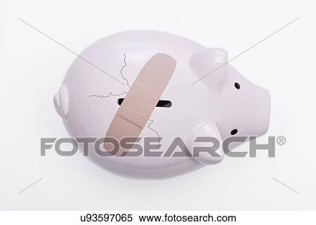 Stock Photography - USA, Illinois, Metamora, Piggy bank with crack and bandage. Fotosearch