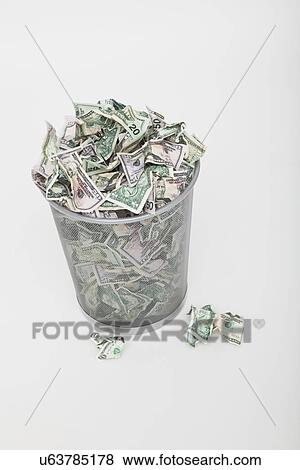 Stock Photo - USA, Illinois, Metamora, Pile of money in trashcan. Fotosearch