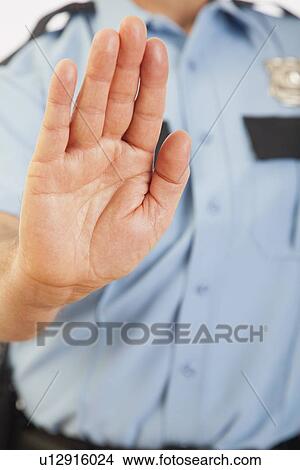 Picture - USA, Illinois, Metamora, Police officer extending arm. Fotosearch