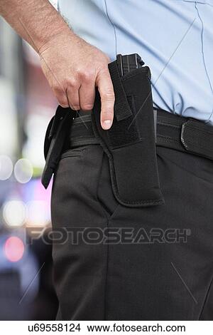Picture - USA, Illinois, Metamora, Police officer wearing gun. Fotosearch