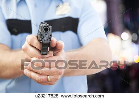 USA, Illinois, Metamora, Police officer aiming gun View Large Photo Image Stock Photo - USA, Illinois, Metamora, Police officer aiming gun. Fotosearch