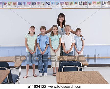Stock Image - USA, Illinois, Metamora, Portrait of teacher with school children (8-9) in classroom. Fotosearch
