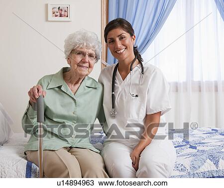 USA, Illinois, Metamora, Portrait of nurse and senior woman with cane sitting on bed View Large Photo Image Stock Image - USA, Illinois, Metamora, Portrait of nurse and senior woman with cane sitting on bed. Fotosearch