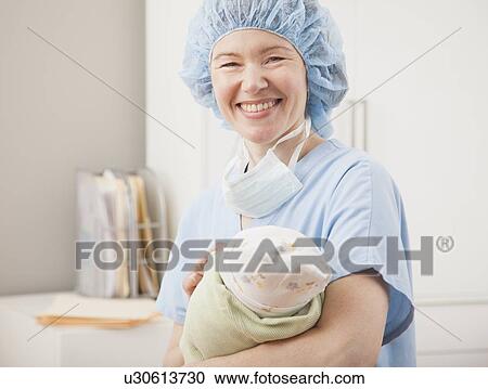 USA, Illinois, Metamora, Portrait of female nurse holding newborn baby View Large Photo Image Stock Image - USA, Illinois, Metamora, Portrait of female nurse holding newborn baby. Fotosearch