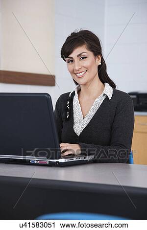Stock Image - USA, Illinois, Metamora, Portrait of smiling woman using laptop. Fotosearch