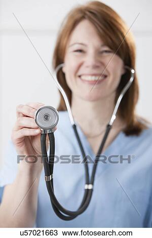 USA, Illinois, Metamora, Portrait of smiling female doctor holding stethoscope View Large Photo Image Stock Image - USA, Illinois, Metamora, Portrait of smiling female doctor holding stethoscope. Fotosearch