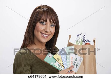 Stock Image - USA, Illinois, Metamora, Portrait of woman holding shopping bag and coupons. Fotosearch